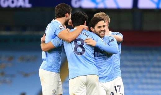 Jogadores do Manchester City se abraçando e comemorando gol