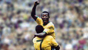 Pelé em comemoração de gol nos braços de companheiro da seleção brasileira de futebol