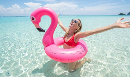 Viagens pós-covid. mulher com bois de flamingo na praia