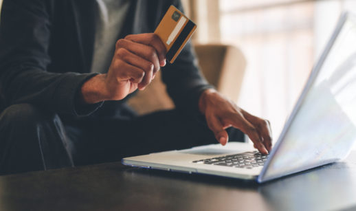 Mulher com laptop e cartão de crédito na mão para comprar no comércio eletrônico