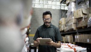 Homem usando tablet conectado a blockchain para organização e rastreamento de produtos