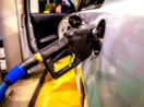 Bomba de combustível presa ao tanque de um carro, com preço da gasolina empurrando a inflação