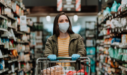 mulher com carrinho de supermercados fazendo compras de mascara