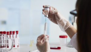 enfermeira retira vacina do frasco com seringa