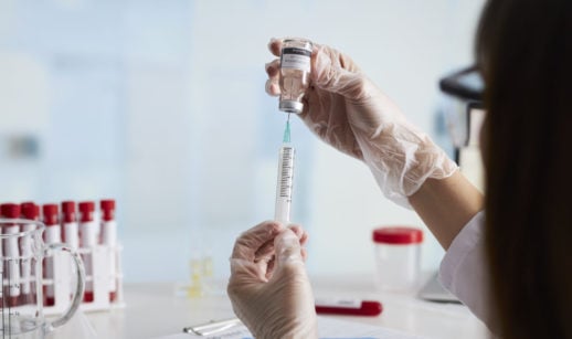 enfermeira retira vacina do frasco com seringa