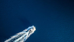 Lancha em meio ao mar calmo azul. Safra Report