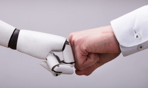 Mãos de robô com inteligência artificial e humano cumprimentando com soquinho