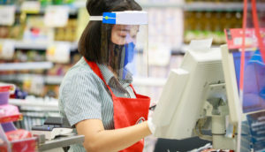 Mulher atendente de caixa em supermercado no comércio