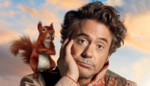 Ator Robert Downey Jr. com esquilo animado no ombro no filme Dolittle