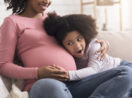 grávida com filha no colo