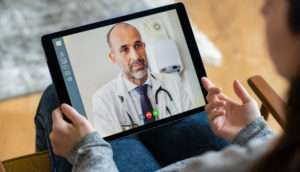 Paciente conversando com seu médico por tablet, em telemedicina