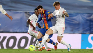 Jogadores Lionel Messi, do Barcelona, Toni Kroos e Vinícius Júnior, do Real Madrid, disputam a bola
