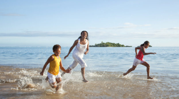 Pessoas felizes de Fiji correndo no mar