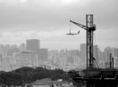 Vista de São Paulo, avião atras de guindaste sobre prédio
