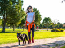 Mulher caminhando em parque com seu cachorro