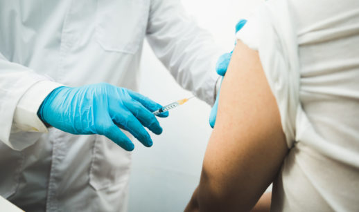 Braço de pessoa sendo vacinado por enfermeiro
