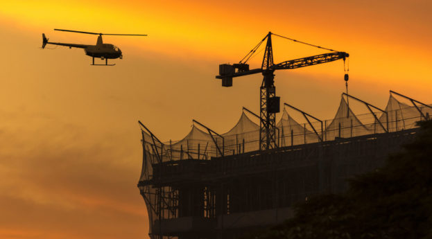 Construção de prédio e helicóptero passando