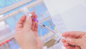 Enfermeira manipulando dose de vacina da covid-19 do PNI