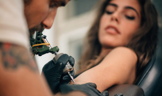 Tatuador remove tatuagem de mulher