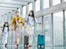 Família de viajantes vacinados entrando em aeroporto de máscara