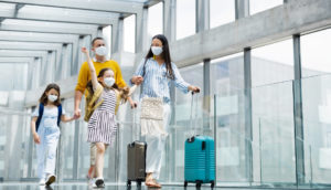 Família de viajantes vacinados entrando em aeroporto de máscara