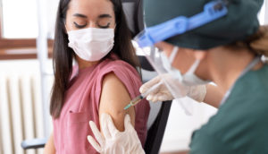 Paciente nos EUA recebendo vacina da covid-19 por enfermeira