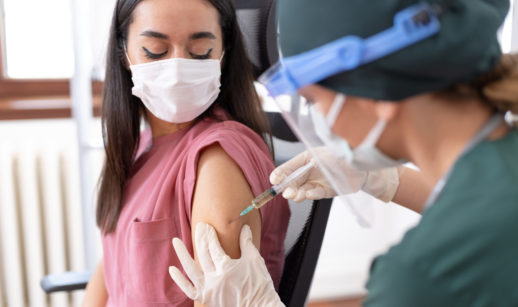 Paciente nos EUA recebendo vacina da covid-19 por enfermeira