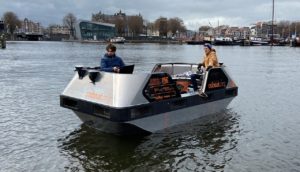 Barco elétrico autônomo em canal de Amsterdã, com dois passageiros a bordo
