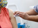 Antecipação do calendário de vacinação em São Paulo, com pessoa sendo vacinada