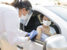 Mulher sendo vacinada no carro