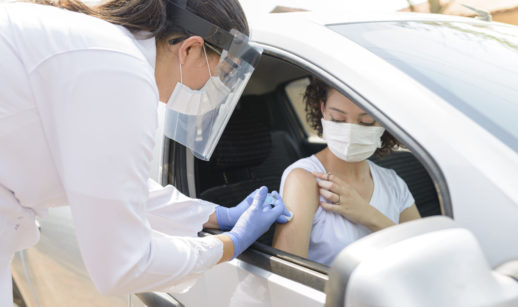 Mulher sendo vacinada no carro
