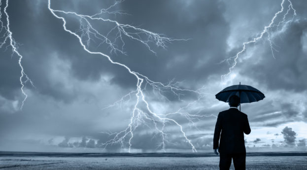 Homem com guarda-chuvas em tempestade