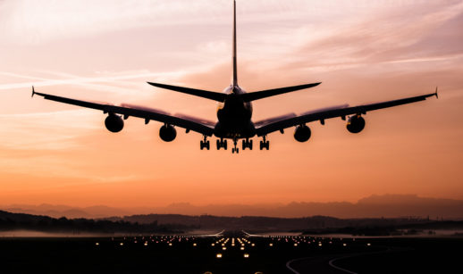 Foto de aeronave pousando em pista iluminada em meio ao pês do sol, alusivo aos aeroportos de São Paulo