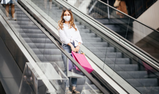 Consumidora com sacola em escada rolante