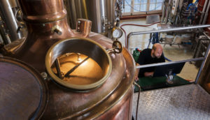 Foto de pequena indústria cervejeira que usa muita energia, com tanque de malte em destaque