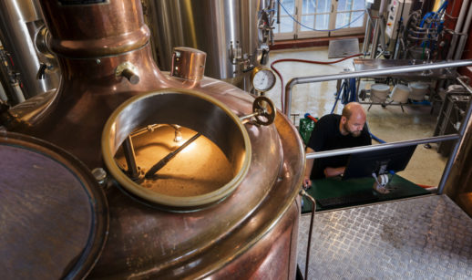 Foto de pequena indústria cervejeira que usa muita energia, com tanque de malte em destaque