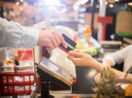 Pessoa pagando compras de mercado em caixa com cartão de crédito, alusivo à inflação 2021