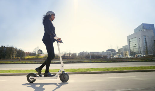 Mulher andando de patinete elétrico em rua, alusivo ao produto permitido pelo sandbox da Susep