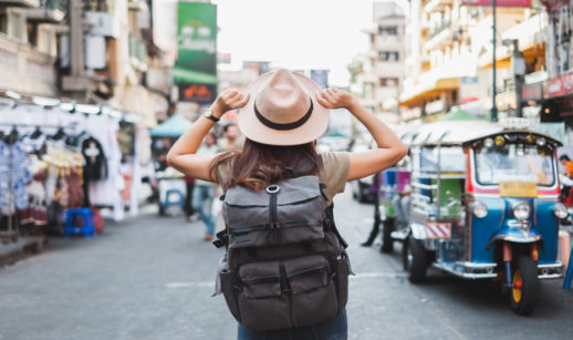 Mulher de costas com mochila e chapéu em viagem, em alusão a alguém que fez o checklist de viagem antes de partir