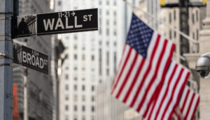 Bandeiras dos Estados Unidos com placa de Wall Street, alusivo aos BDRs para investir em agosto