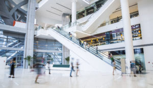 Escadas rolantes com pessoas em shopping, alusivo à Aliansce (ALSO3)
