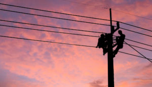 Eletricitários reparam rede elétrica em poste