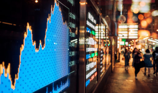 Tela de mercado financeiro em rua movimentada com gráficos, alusivo aos índices atrelados aos ETF