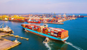 Porto chinês visto de cima, com navio entrando no cais cheio de contêineres, alusivo ao comércio do G20