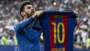 Lionel Messi, segurando a camisa do Barcelona e mostrando à torcida em jogo contra o Real Madrid