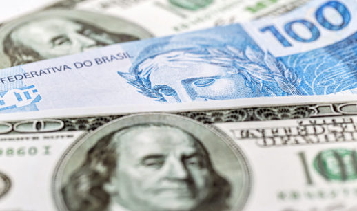 Notas de dólar e real sobrepostas