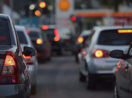 Trânsito visto de trás com veículos de lanterna de freio acesa, alusivo ao seguro de veículo