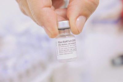 Mão segurando dose de vacina da Pfizer contra a covid-19