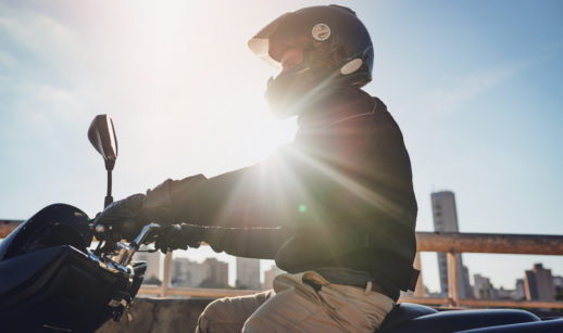 Motociclista andando de moto com sol ao fundo, alusivo às vendas de motos novas
