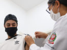 Jovem se vacinando contra a covid-19 em São Paulo, alusivo à virada da vacina